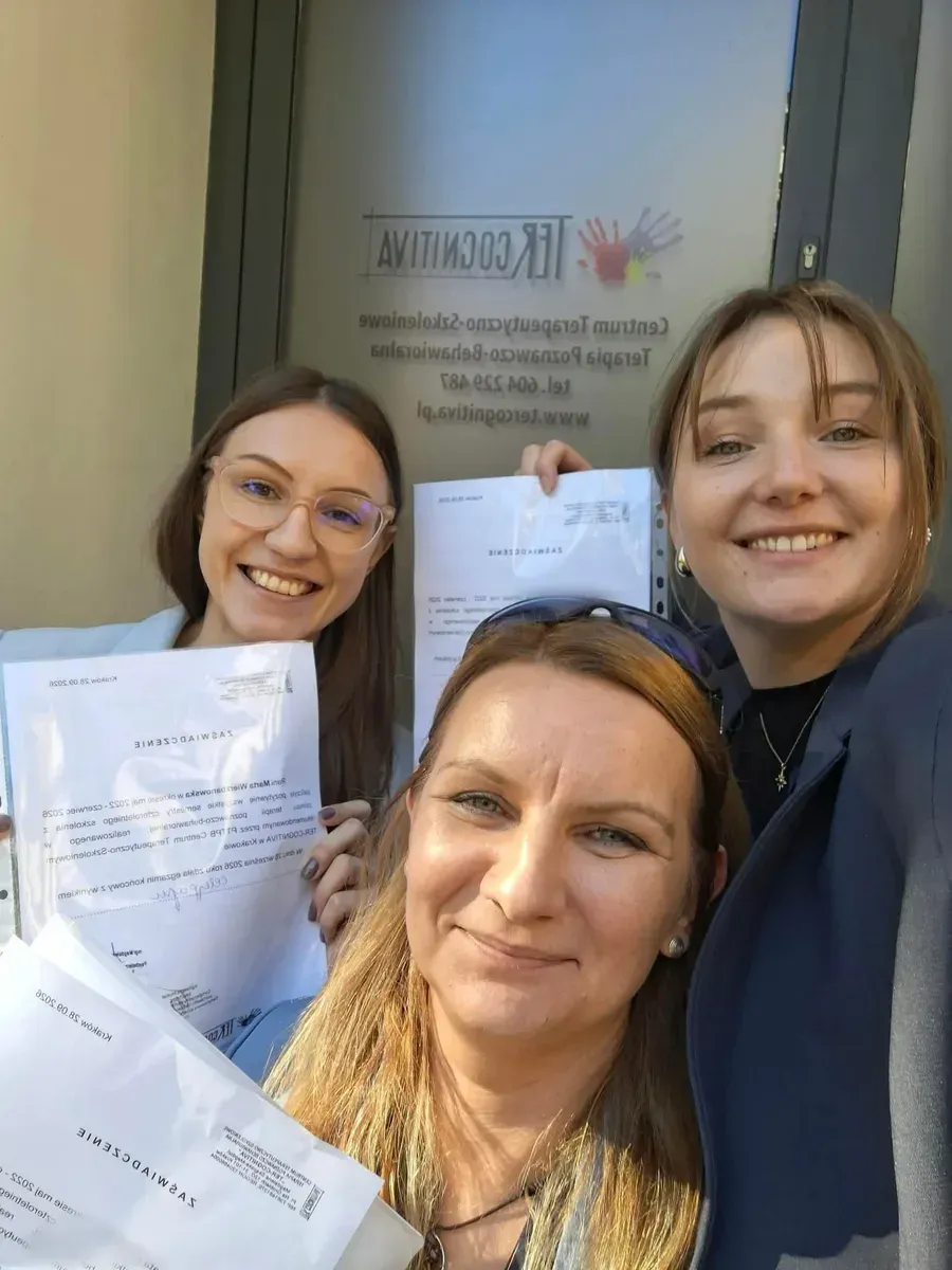Marta Wierzbanowska (po lewej, w okularach) z dwiema koleżankami z grupy szkoleniowej przed wejściem do Centrum Ter-Cognitiva w Krakowie. Wszystkie trzymają zaświadczenia o ukończeniu szkoły.